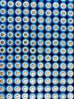 A close-up image of a grid of cylindrical lithium-ion batteries. The batteries are arranged in rows and columns, with their blue plastic casings and silver metallic tops clearly visible. photo