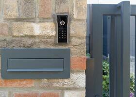 Modern mailbox and intercom on brick wall photo