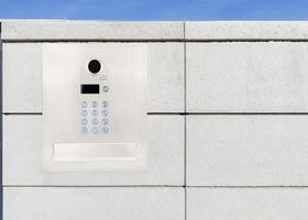 Security keypad and camera on concrete wall photo