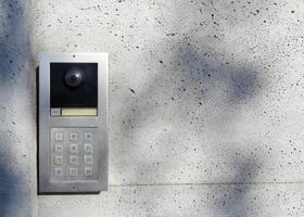 Metal intercom with keypad on concrete wall photo