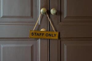 Staff only gold label hanging on knob in front of staff room photo