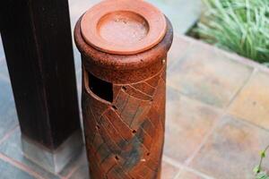 Rustic Clay Trash Can in Outdoor Setting photo