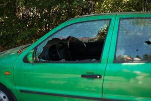 Broken glass on the passenger door of a passenger car parked. The concept of crime of car theft, theft of valuables photo
