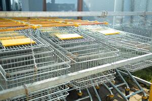 Shopping carts all lined up ready to be used to get groceries at store photo