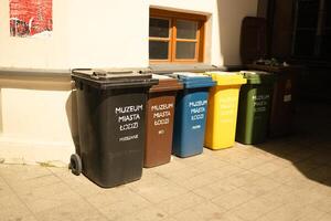 Plastic pollution problem. Large multi-colored garbage plastic bins for sorting garbage near a building on the street photo