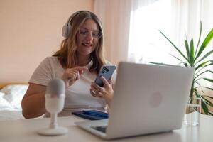 30s female teacher teach by call explain educational material to trainee distantly seated on couch in living room at home. Friends communicating use videoconference app concept, pc screen view photo