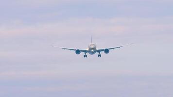 Passenger plane with unrecognizable livery approaching landing. Plane in the sky, front view video