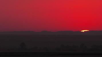 Natural background. Spectacular view of a vibrant red sunset sun setting on the horizon, inspiring awe and tranquility video