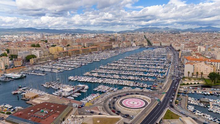 Aerial View of the Vieux-Port in Marseille, France, with Hundreds of Boats Docked, Surrounded by the City's Historic Buildings and Scenic Hills in the Background