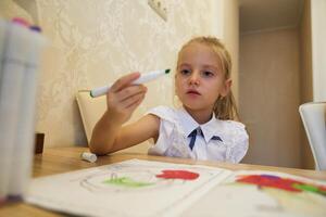 Young girl engaged in creative coloring activity at home during day photo