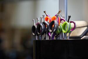Colorful hair cutting scissors organized in a salon display at midday photo