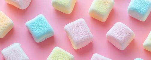 Colorful marshmallows on pastel pink background photo