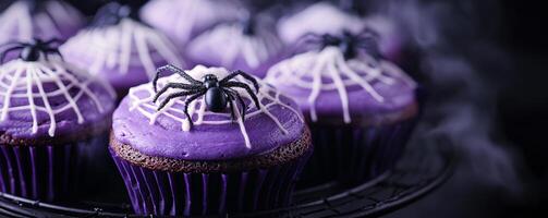 Halloween cupcakes with purple frosting and spider decoration, festive dessert on a wire rack. spooky and seasonal vibes concept photo