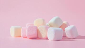 Pastel colored marshmallows on pink background, minimalist candy concept photo