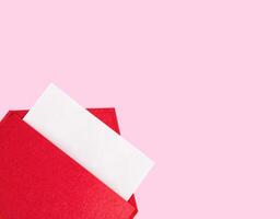 Red open envelope with a sheet of paper mock up on a pink background with copyspace and mock up. Valentine's day holidays concept and love notes, christmas and new year letters for Santa Claus photo