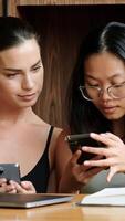 Two interracial students in a modern office or library discuss ideas for completing an assignment, sharing thoughts and inspiration. The pleasant environment enhances their productive collaboration video