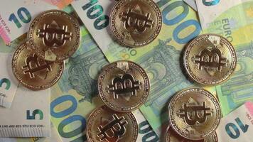 Bitcoin Coins on the 100 Euro Banknotes - Top View. Euro Money Cash and Cryptocurrency. Hundred Euro Bills. Finances, Exchange, Blockchain and Electronic Money Concept - Slow Rotation Right video