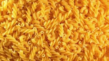 Uncooked Fusilli and Chifferi Rigati Pasta - Top View. Fat and Unhealthy Food. Classic Dry Macaroni, Rotating Background. Raw Different Macaroni Pasta Texture - Rotate Left video