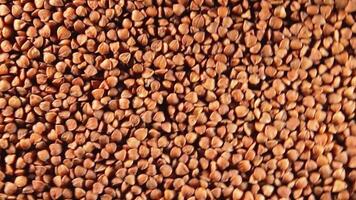 Dry Uncooked Brown Buckwheat Groats, Slowly Rotating Counter-Clockwise - Top View. Raw Large Buckwheat Grains. Russian, Ukrainian and Belarusian Culture. Rotation Left video