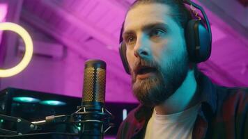 Focused glad Caucasian man gamer stream commenting game in microphone look monitor male play virtual strategy online cyber sport addict tense player blogger screaming win successful match victory home video