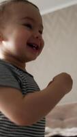 Smiling happy toddler boy runs by the room. Kid runs up to the wall and sticks something on it. Low angle view. Vertical video