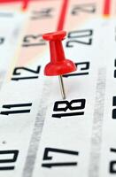 pushpin on a calendar date, reminder and time concept photo