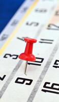 pushpin on a calendar date, reminder and time concept photo