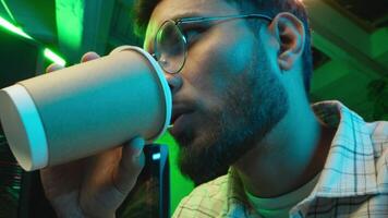 Close-up Caucasian man programmer male specialist engineer developer guy freelancer drinking coffee tea thinking in workplace looking computer screen create innovative software developing application video