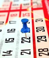 pushpin on a calendar date, reminder and time concept photo