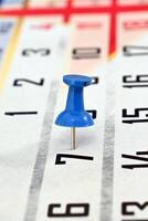 pushpin on a calendar date, reminder and time concept photo
