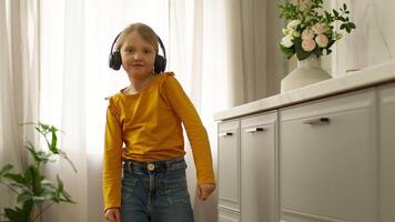 Little European girl child daughter dancing home room headphones earphones gadget electronic technology digital device childhood listen music dancer movement rhythm wireless broadcasting playlist song video