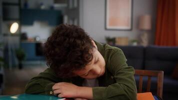 Tired sleepy chronic fatigue health problem insomnia medicine sick exhausted overload African American little boy lack energy sleeping son kid child at home studying lying on books at table education video