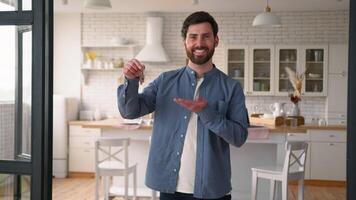 Happy satisfied smiling Caucasian dad successful homeowner realtor male showing keys rejoicing moving in new house property relocating man adult guy buying dwelling insurance owning real estate home video