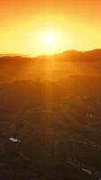 Beautiful bright sun hiding behind the mountains. Peaceful scenery of Napa, California, USA at setting sun. Aerial view. Vertical video