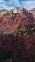 Stunning huge rocks of diverse colors and shades. Canyons of Zion National Park in Utah, USA at backdrop of blue sky with clouds. Vertical video