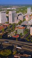 Lively traffic of Sacramento, California, USA. Drone approaching the beautiful downtown with fine architecture on sunny day. Vertical video