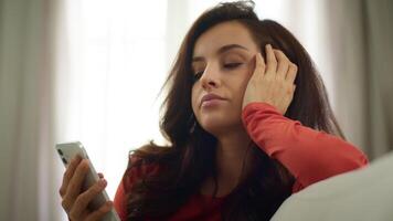 Bored sad Caucasian upset woman lazy female girl unhappy client user scrolling mobile phone smartphone browsing social media online app on couch burnout problems boredom depression indoors home room video