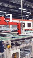 Automated factory interior. Automated robotic arms assembling innovative product solar panels Vertical video