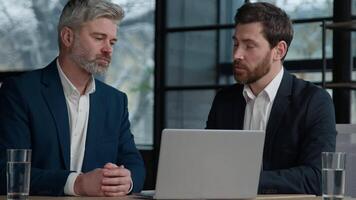 Caucasian men businessmen employees coworkers business partners discussing online project strategy plan discuss presentation on laptop in office consult client interview hiring teamwork negotiation video