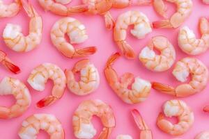 Fresh raw pink shrimp arranged on a bright pink background for culinary presentations and recipes photo