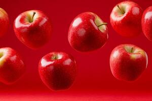 Bright red apples bouncing mid-air against a rich red backdrop showcasing their vibrant color and shine photo
