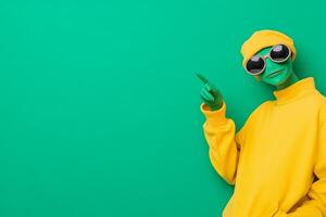 A playful green alien pointing at the viewer against a bold neon green background photo