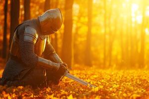 Knight kneeling with his sword in a dimly lit autumn forest at sunset displaying soft golden light photo
