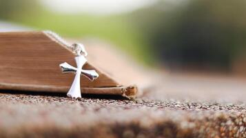 Shiny metal cross leaning against an old open book symbolizing the spread of Jesus Christs love among Christians reflecting faith devotion and the importance of Christian teachings. photo