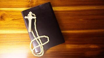 Brown wooden cross on a brown book symbolizing the spread of Jesus Christs love among Christians reflecting faith devotion and the importance of Christian teachings. photo