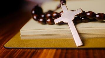 Shiny copper cross leaning against an old open book symbolizing the spread of Jesus Christs love among Christians reflecting faith devotion and the importance of Christian teachings. photo