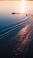 Motion of boats at sunset. Amazing view on the evening river with motor boat leaving paths on water surface. Aerial view. Vertical video