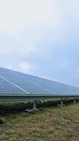 eco solar bateria em a Relva debaixo azul céu. Inovativa tecnologia dentro eletricidade. fotovoltaico solar painéis para renovável energia. vertical video