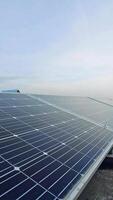 solar painéis dentro linhas debaixo a azul céu. fotovoltaico painéis dentro luz solar. alternativo fonte do energia. Inovativa solar plantar. vertical video