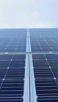 azul solar painel debaixo a Claro céu. fotovoltaico bateria dentro a luz solar. renovável energia. fechar-se. movimento Câmera topo abaixo. vertical video